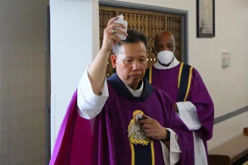Father Joseph Cao, assisted by Deacon Clarence McDavid, blesses the parts of the church affected by an Aug. 30 break-in, during a Mass of reparation at Curé d'Ars Catholic Church in Denver, Colo., Sept. 1, 2021.